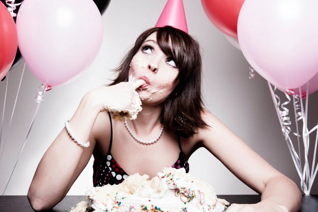 Woman eating birthday cake with hands